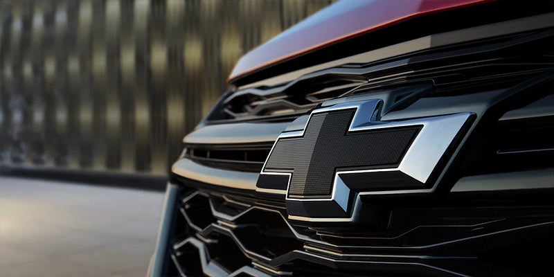Chevrolet logo prominently displayed on the front grille of a red car.