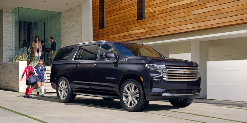 A 2022 Chevrolet Suburban parked in front of a residential house