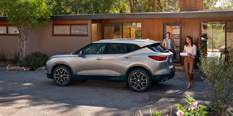 A 2024 Acura parked in front of a residential house.
