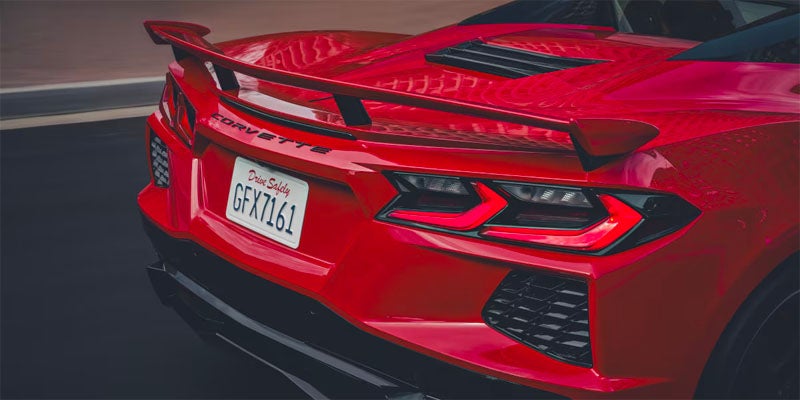 Rear view of a sleek red sports car showcasing its aerodynamic design and shiny finish.