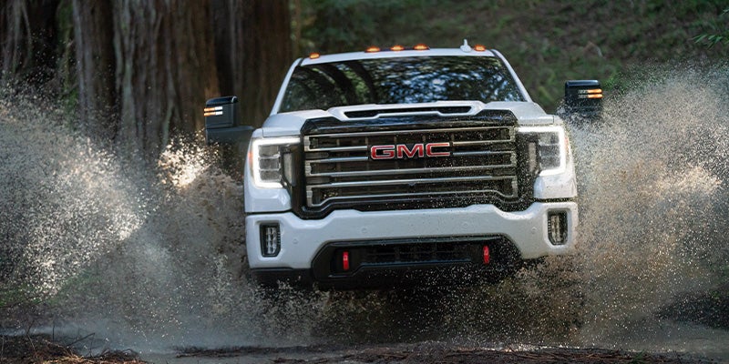 A GMC Sierra 3500 truck is prominently featured in a video presentation